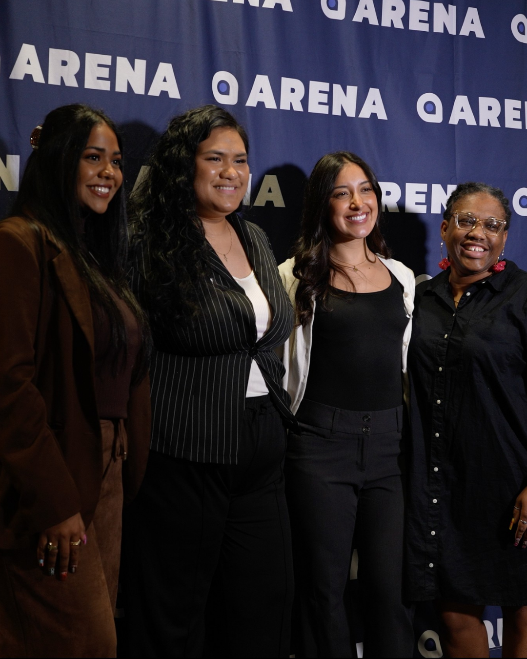 Four guests together in front of an Arena backdrop